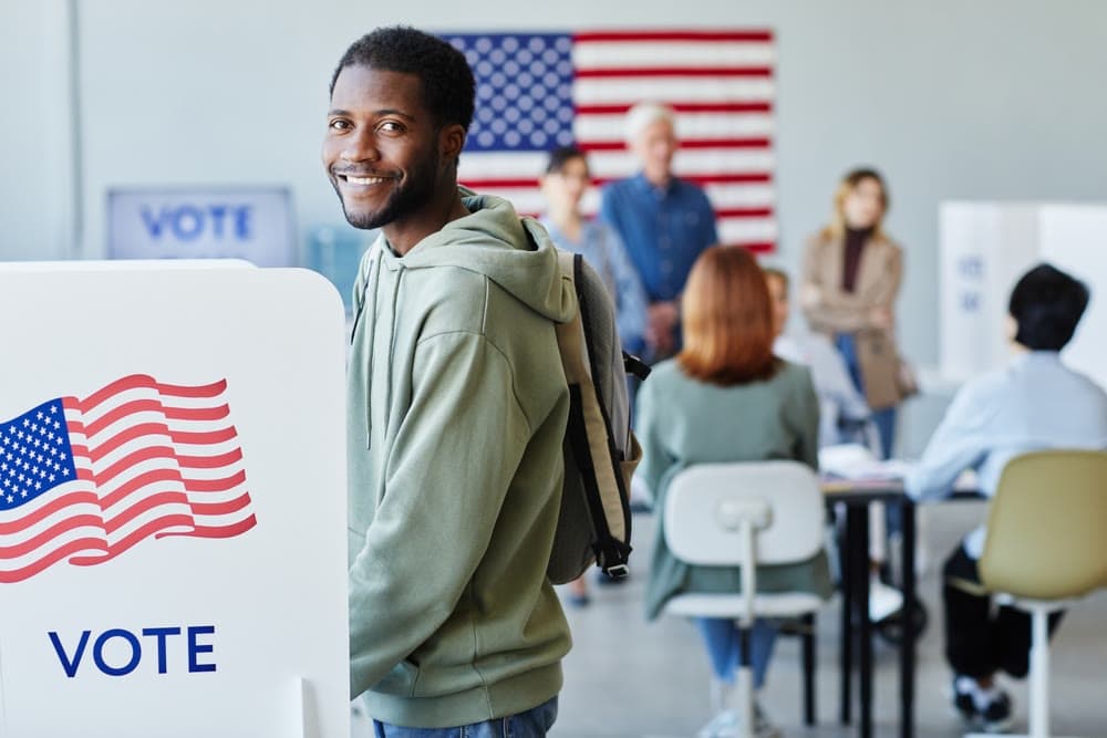 A smiling voter at a polling place voting booth