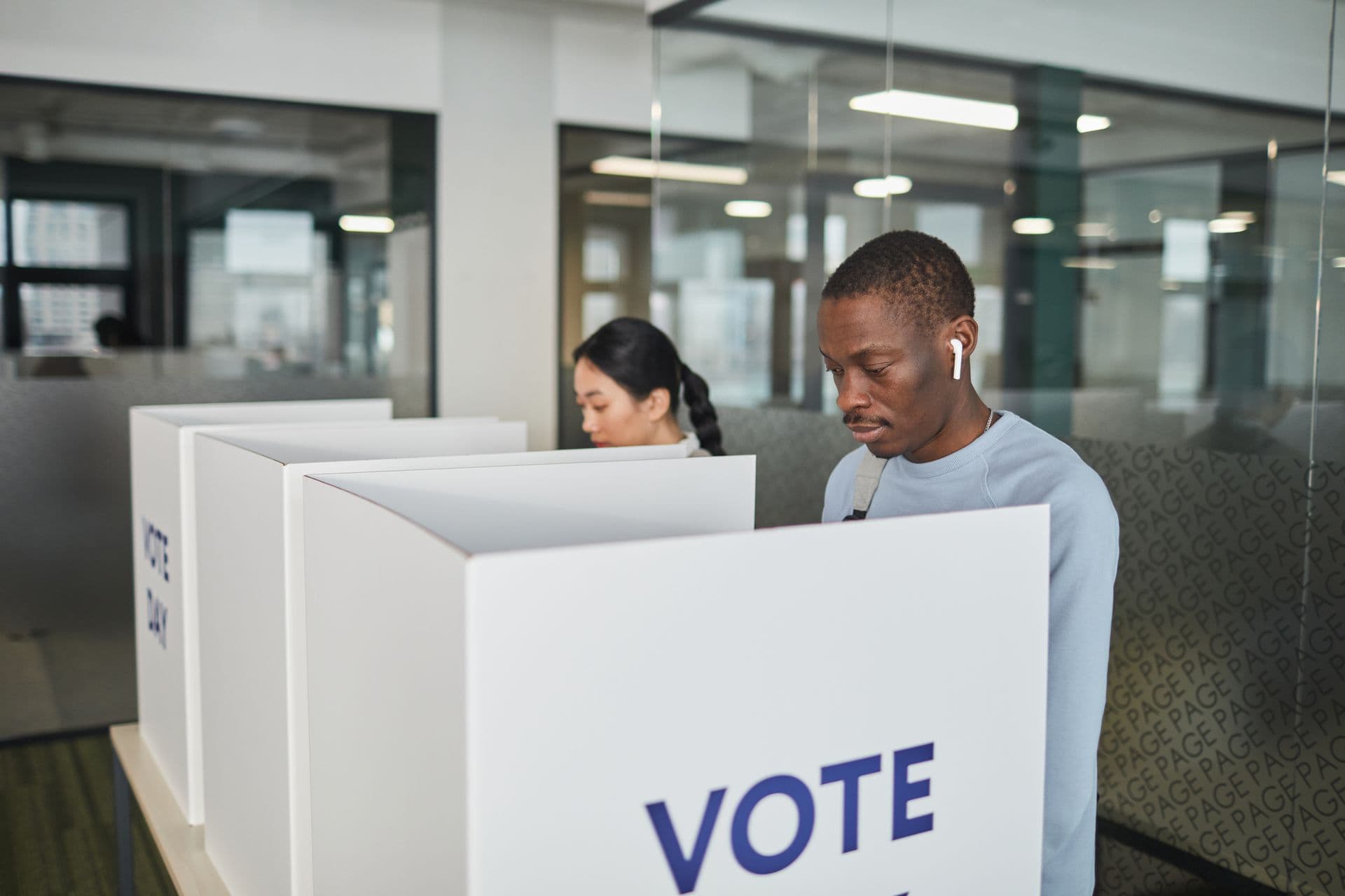 A voter filling out his ballot at a voting booth